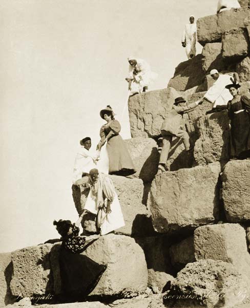 Tourists ascending the pyramids with native guides (b/w photo)  à Photographe anglais