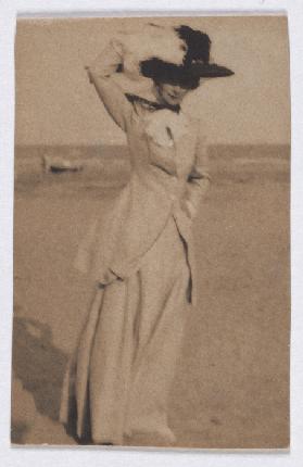 Young lady with big hat on the beach, en face