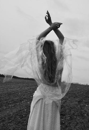 Topless girl in a transparent raincoat under the cold wind.