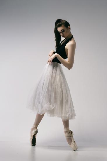 The coquetry. a young ballerina in a black skirt and Chopin is standing on pointe shoes