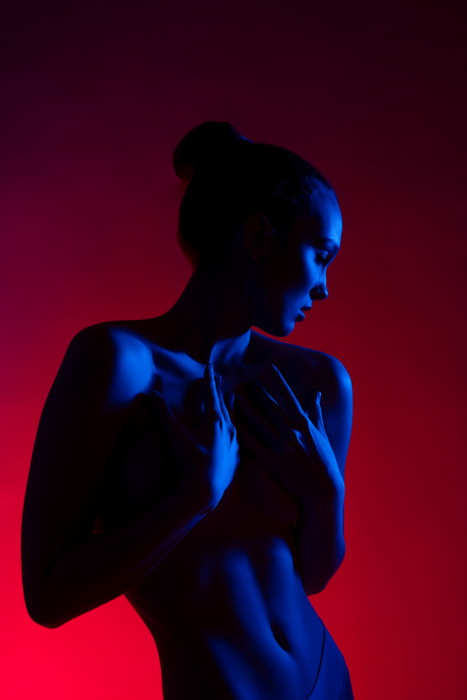 Young woman in casual clothes standing under neon light à Andrey Guryanov