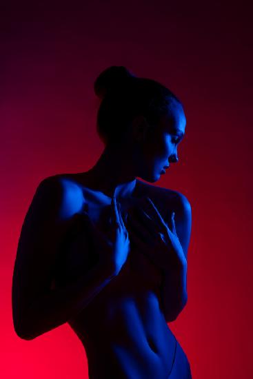 Young woman in casual clothes standing under neon light