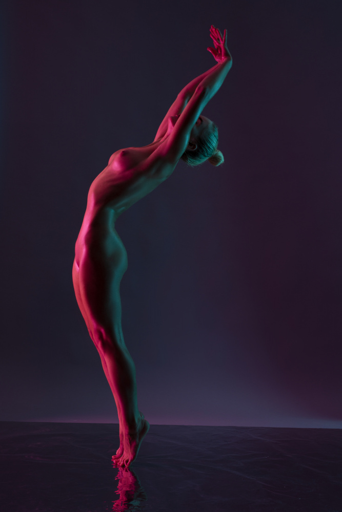 Young naked woman dance against dark purple background à Andrey Guryanov