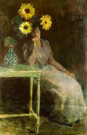 Femme étant assise à côté d'un vase avec des tournesols
