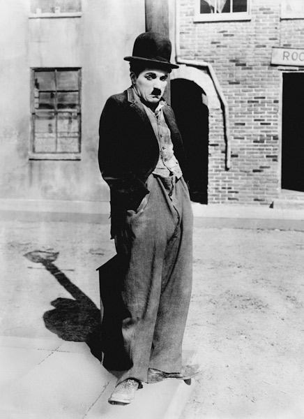 A dog 's life by and with Charlie Chaplin , standing in a street, hands in pockets. Los Angeles à Photographies de Célébrités