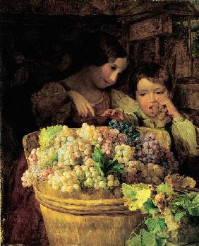 deux enfants à un Buette  rempli avec des raisins