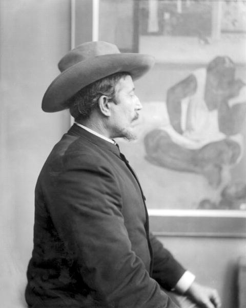 Paul Gauguin (1848-1903) in front of his canvases (b/w photo)  à École française