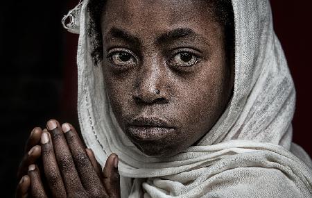 Ethiopian girl praying at a religious ceremony.