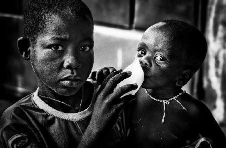 Quenching his brother´s thirst with a frozen water bag - Benin