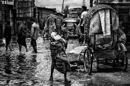 Man holding his child in the flooded streets of Bangladesh