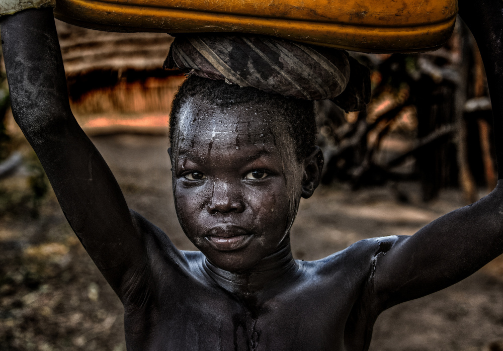 South sudanian child carrying a water containera à Joxe Inazio Kuesta Garmendia