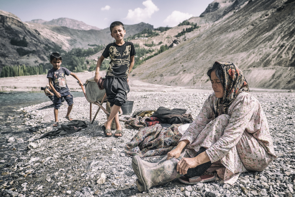 A Tajik woman is preparing to wash in the stream à Marcel Rebro