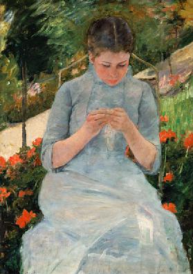 Jeune femme tricotant dans le jardin