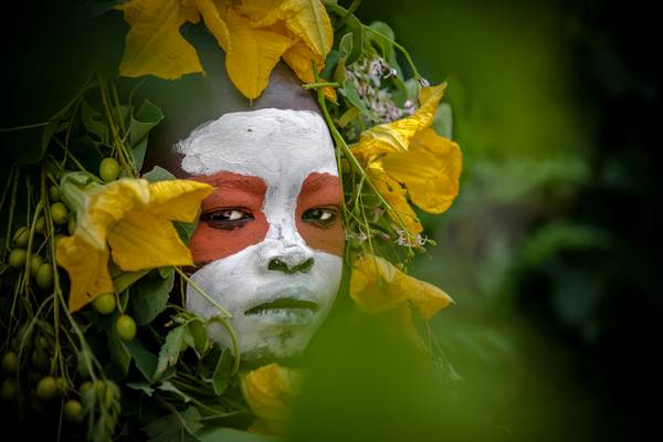 Porträt Mädchen aus dem Suri / Surma Stamm mit Blumen, Omo Valley, Äthiopien, Afrika à Miro May