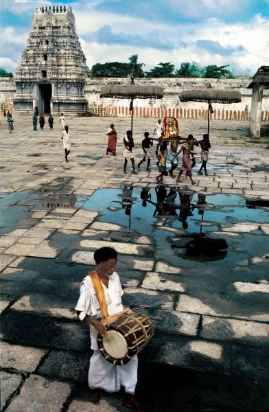 Drummer and devotees reflected in pool of water (photo)  à 