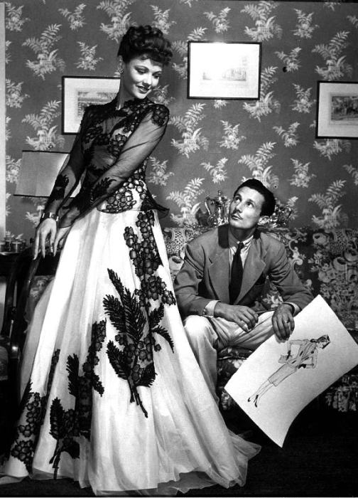 fashion designer Oleg Cassini showing his drawings to Gene Tierney to show her the clothes for film  à 