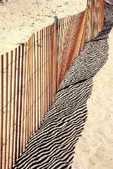 Reflet de clôture sur le sable (photo)