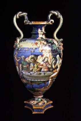 Maiolica urn with two handles in the shape of serpents, the body decorated with an al fresco banquet