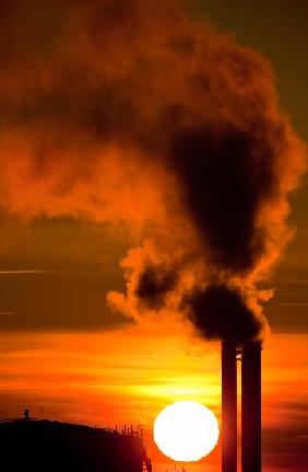 Qualmende Schornsteine im Sonnenaufgang