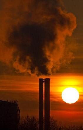 Qualmende Schornsteine im Sonnenaufgang