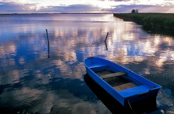 Blaues Boot am Seeufer mit Wolkenstimmung à Robert Kalb