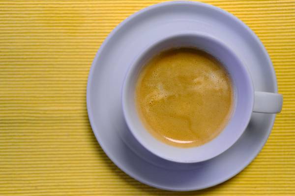 Kaffeetasse mit Kaffee auf gelbem Untergrund à Robert Kalb