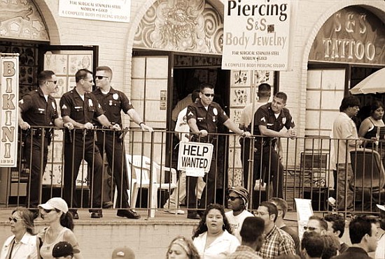 Police gathered behind a ''Help Wanted'' sign, 2004 (b/w photo)  à Stephen  Spiller